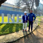 Director del INH y alcalde de Peñaflor de pie junto a letras volumétricas INH, con el laboratorio de fondo.