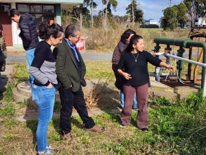 Una funcionaria explica sobre el funcionamiento del Laboratorio de Calidad del Agua a invitados del INH, al aire libre.