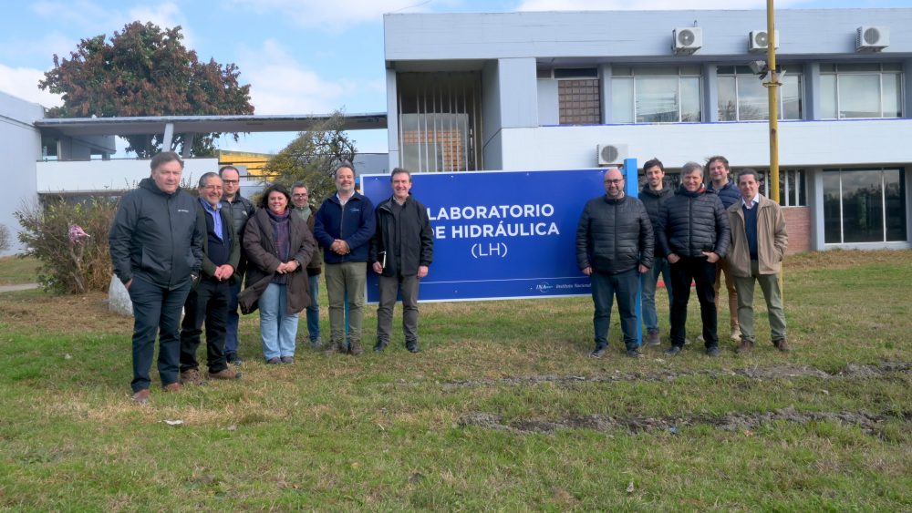 Fotografía grupal de la visita al aire libre, con el Laboratorio de Hidráulica al fondo.
