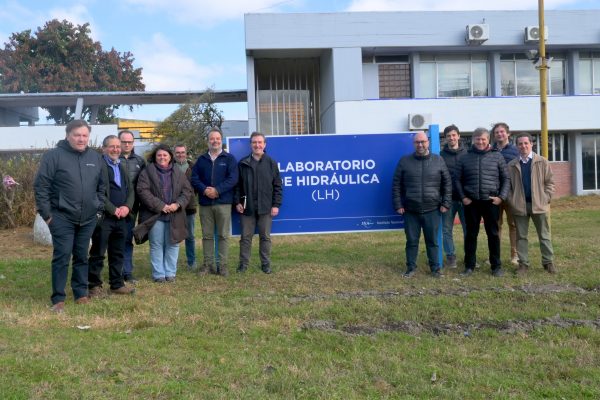 Fotografía grupal de la visita al aire libre, con el Laboratorio de Hidráulica al fondo.